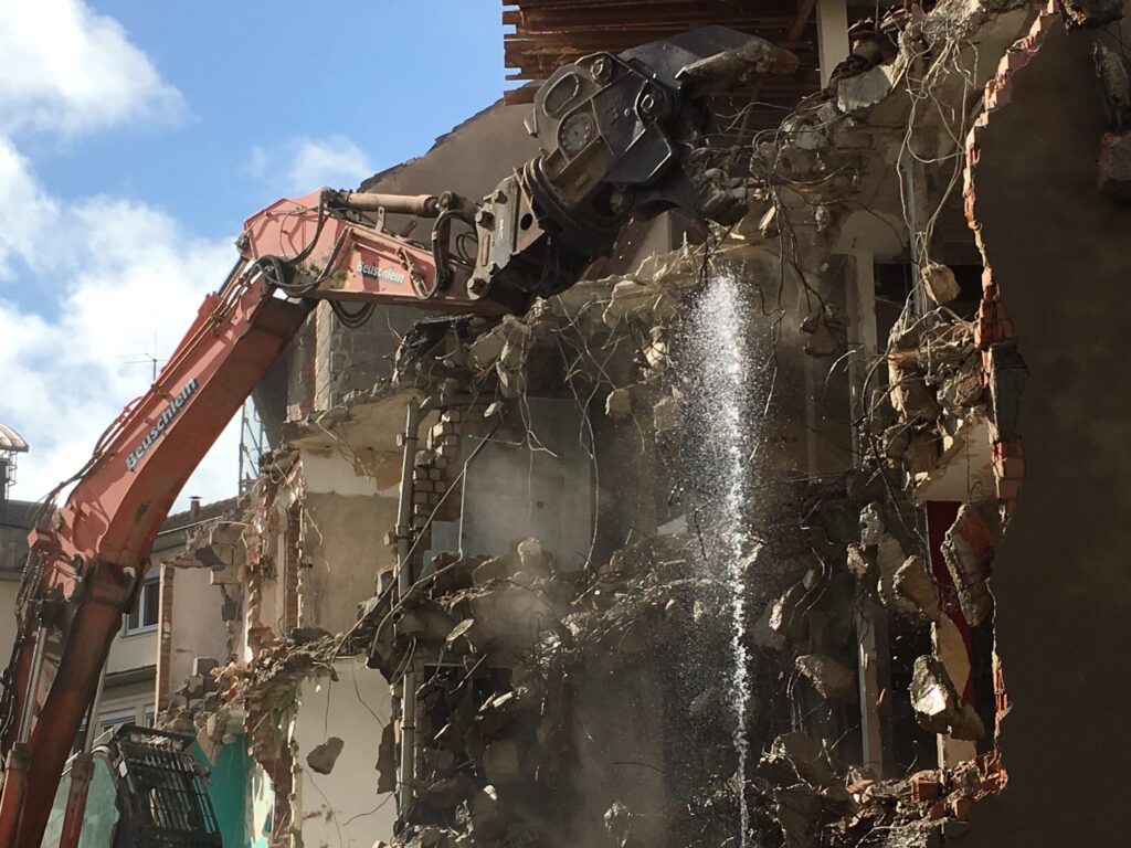 Bagger reißt altes Gebäude ab.