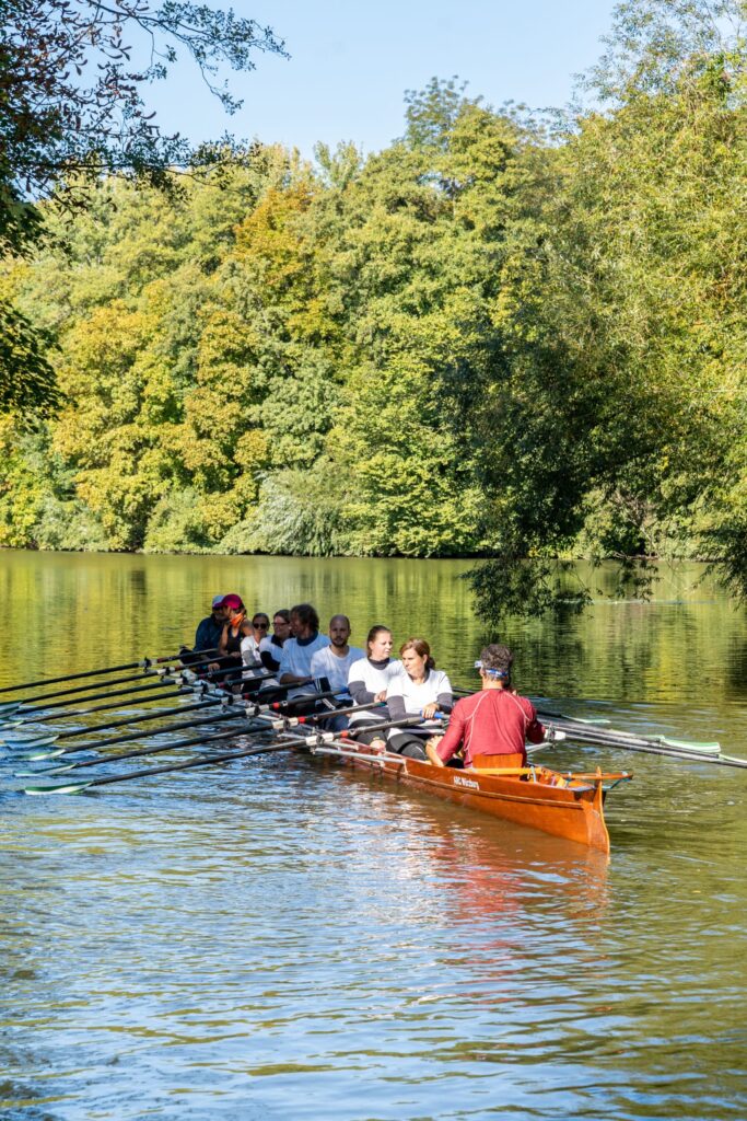 Ruderteam auf Fluss bei sonnigem Wetter