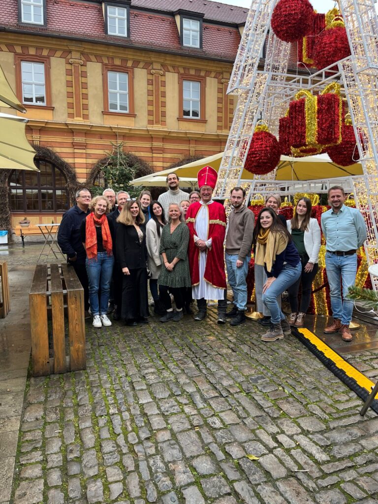 Gruppe posiert vor Weihnachtsdekoration im Freien.