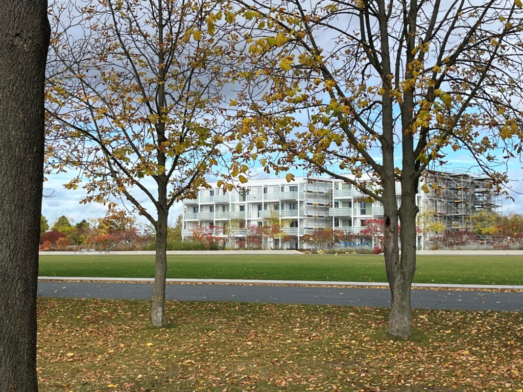 Herbstbäume vor einem modernen Gebäude.
