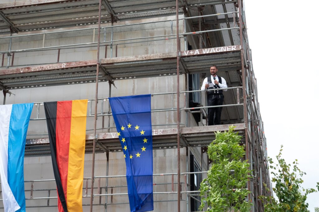 Mann auf Baustelle mit deutschen und EU-Flaggen