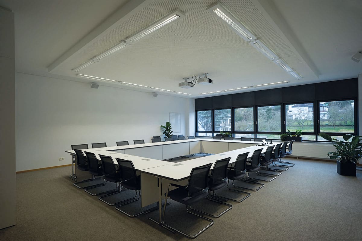 Moderner Konferenzraum mit Tisch und Stühlen.