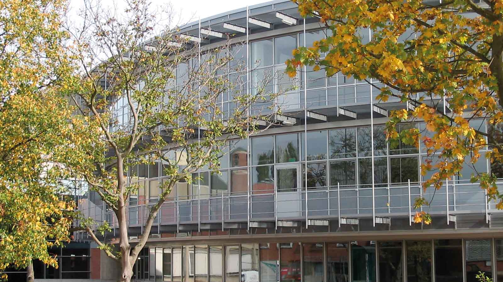 Moderne Gebäude mit Herbstbäumen im Vordergrund.