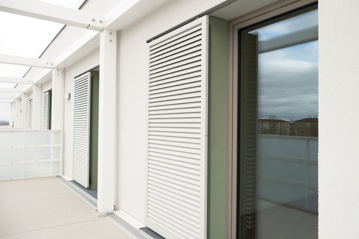 Moderne Balkontür mit weißen Lamellenjalousien