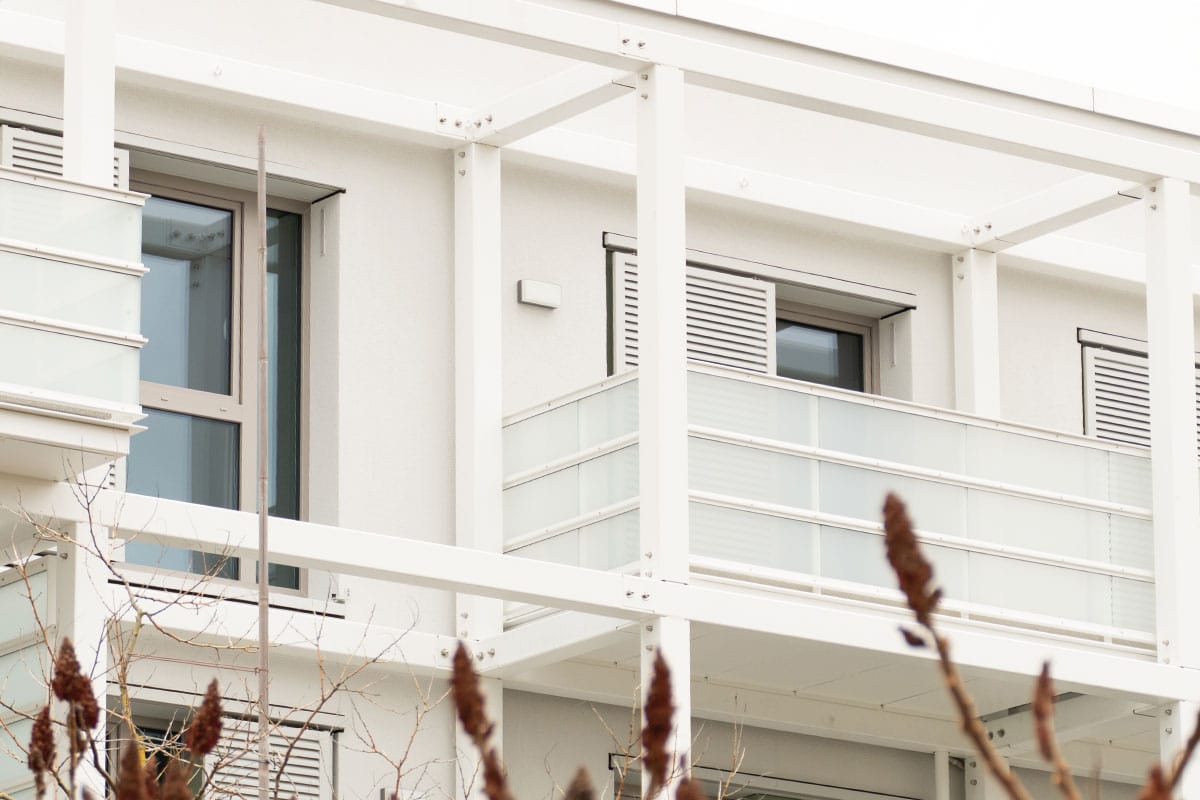 Moderner Balkon mit Glasgeländer und Rollläden