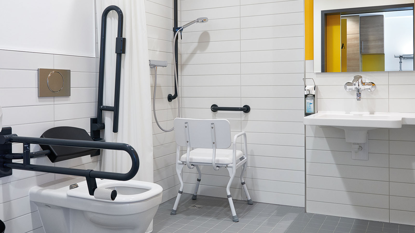 Barrierefreies Badezimmer mit Haltegriffen und Duschstuhl