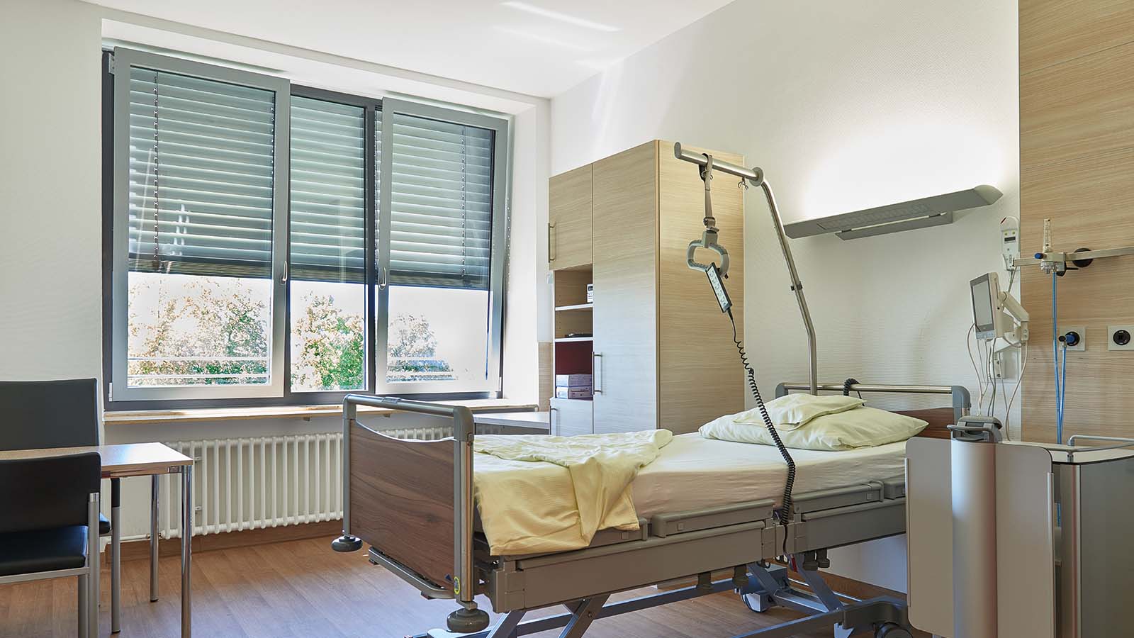 Modernes Krankenhauszimmer mit Bett und Geräten.