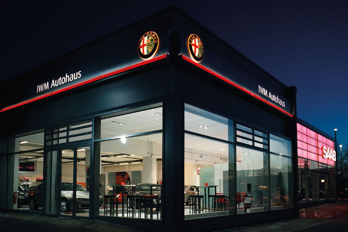 Autohändler mit Alfa Romeo und Saab Logos bei Nacht