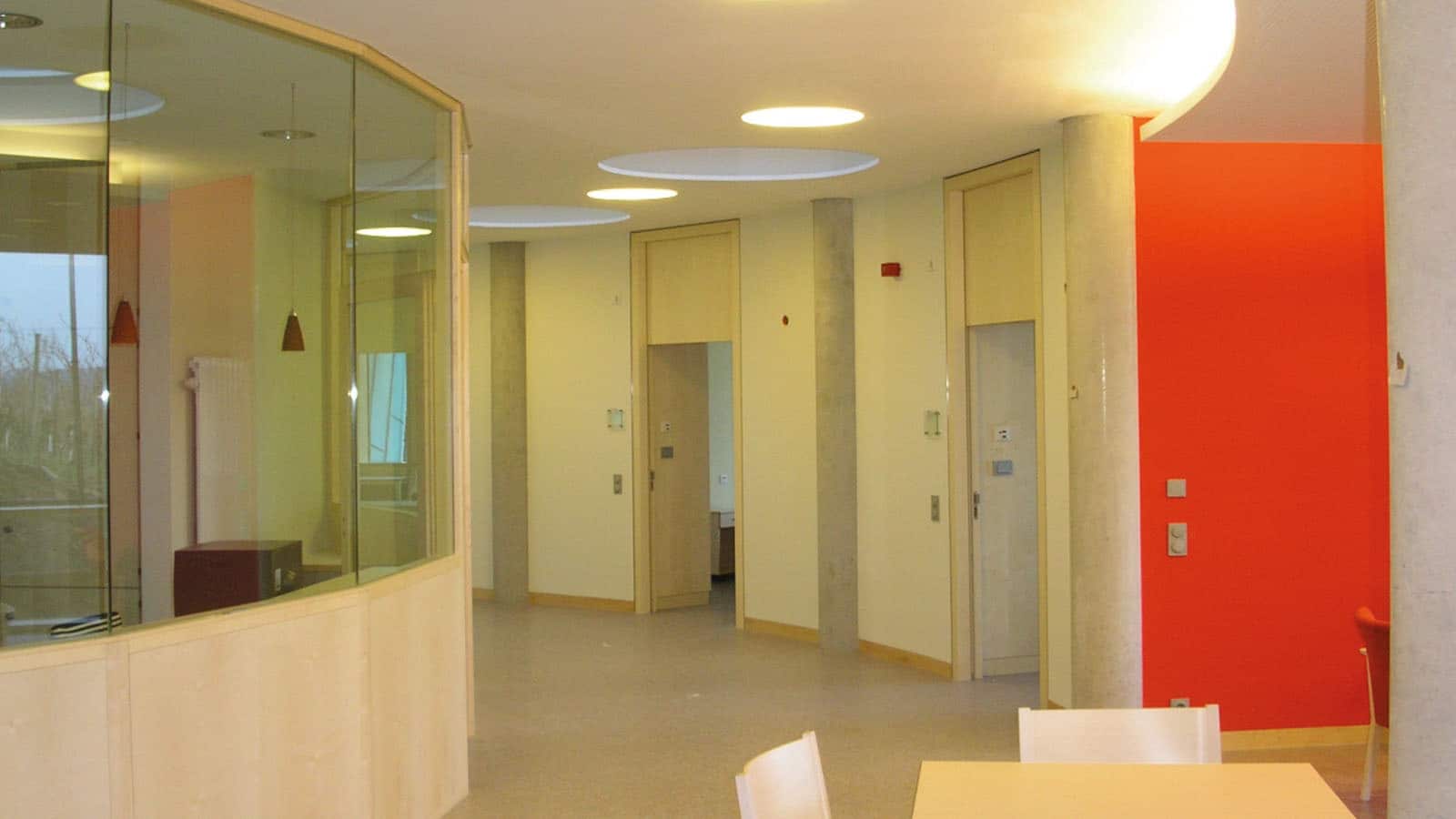 Modernes Büro mit Glaswänden und roter Akzentwand