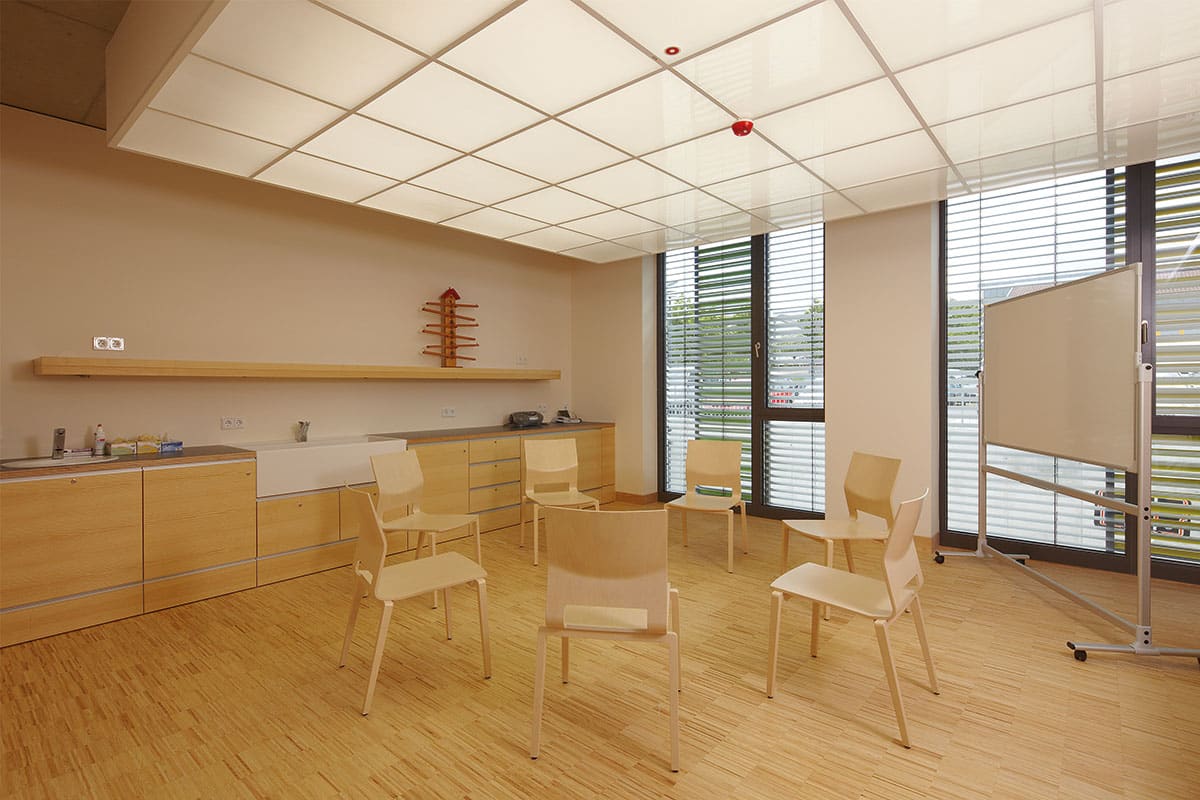 Moderner Besprechungsraum mit Holzmöbeln und Tafel.