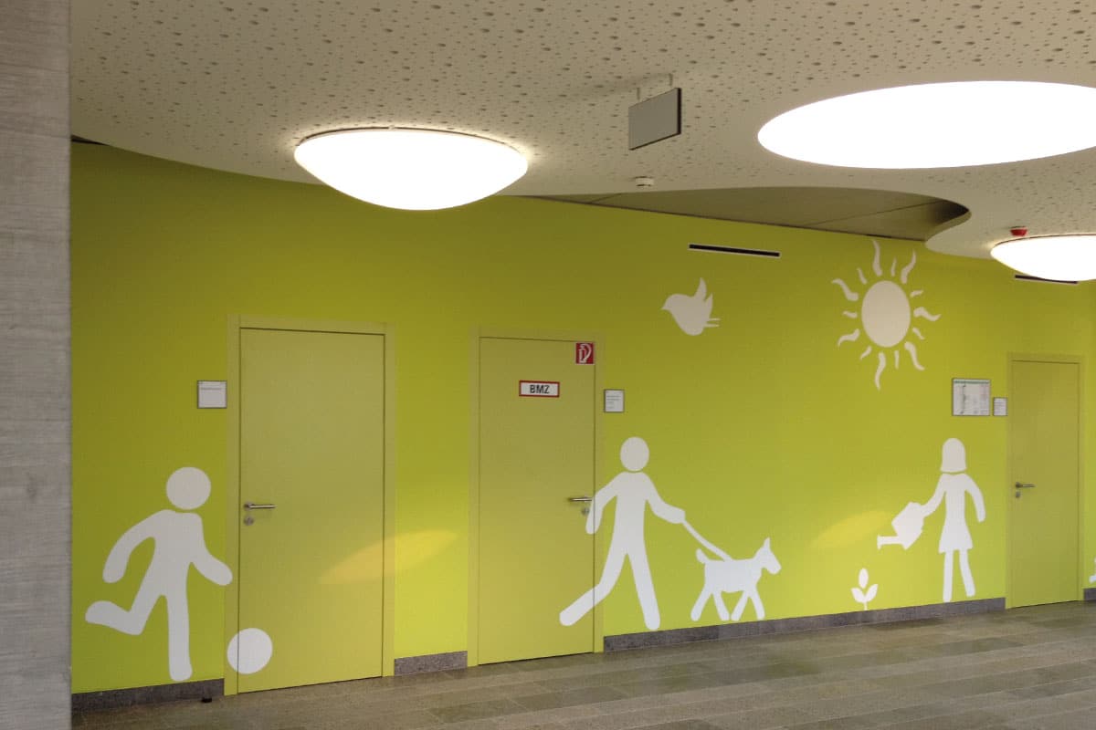 Grüne Wand mit weißen Piktogrammen