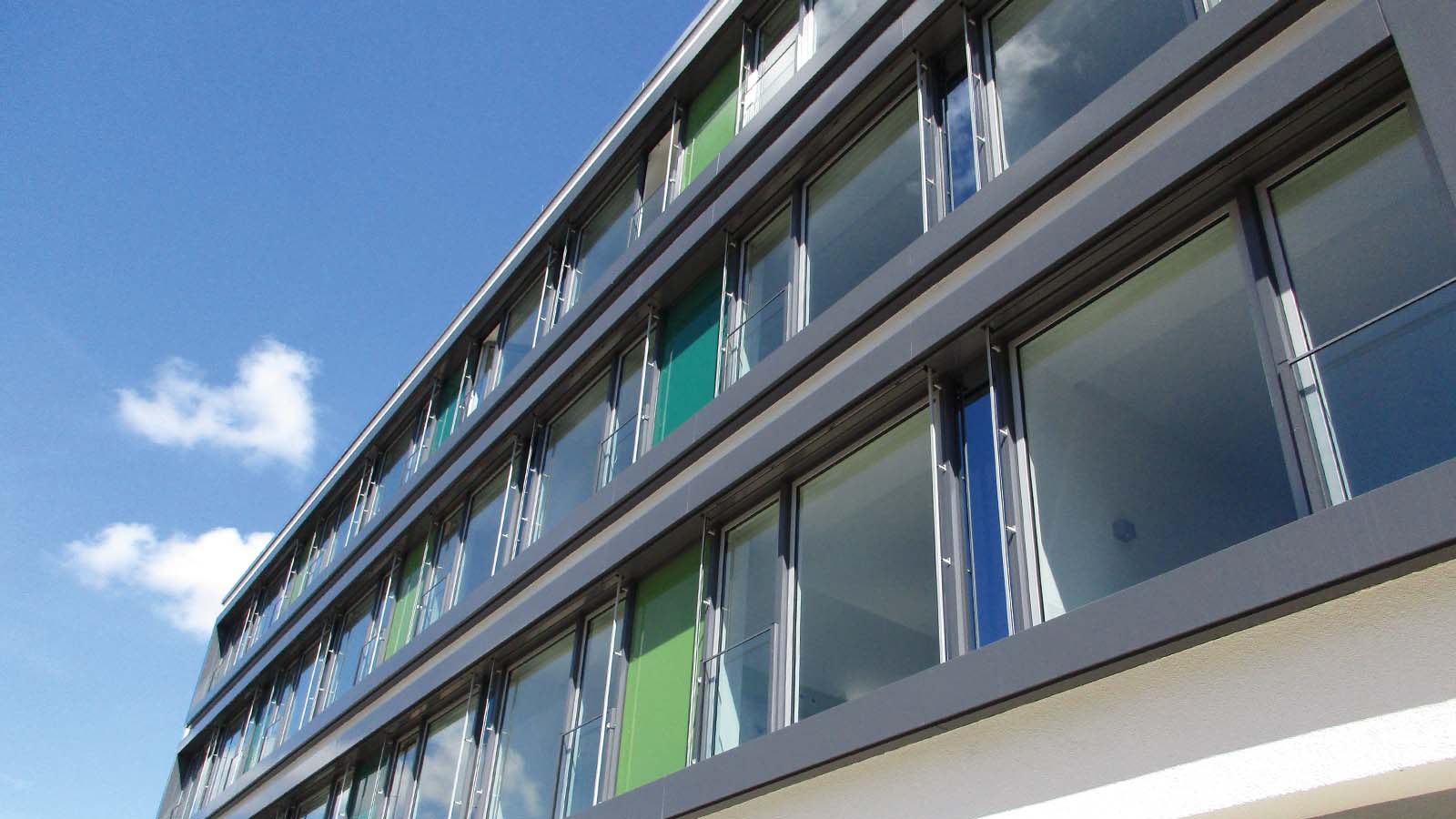 Modernes Bürogebäude mit Glasfassade und blauem Himmel