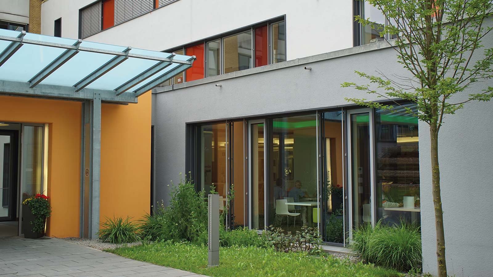 Moderner Bürogebäude-Eingang mit Glasvordach.