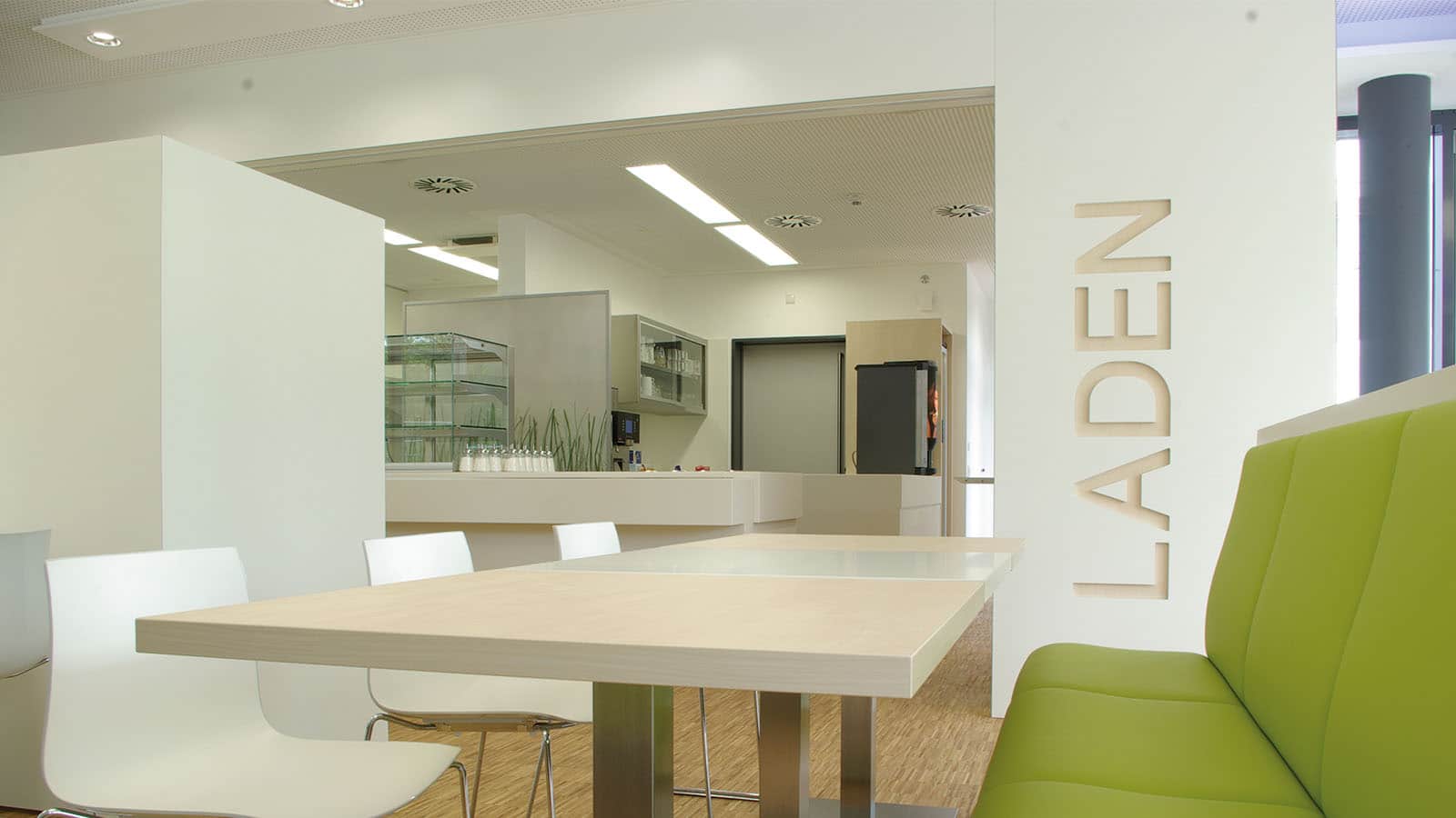 Moderner Speiseraum mit grünen Sitzgelegenheiten.