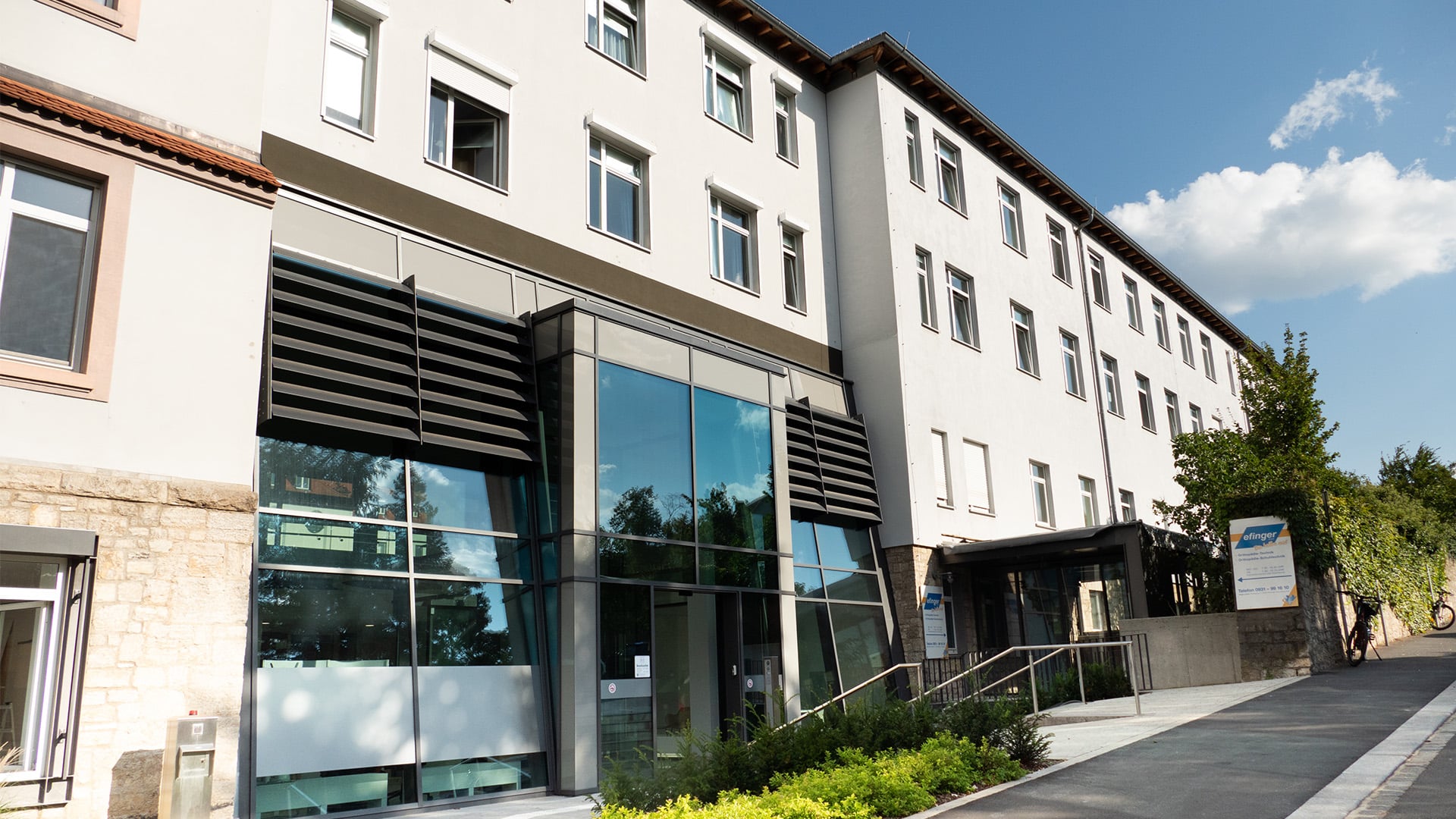 Modernes Bürogebäude mit Glasfassade und Eingangsbereich.