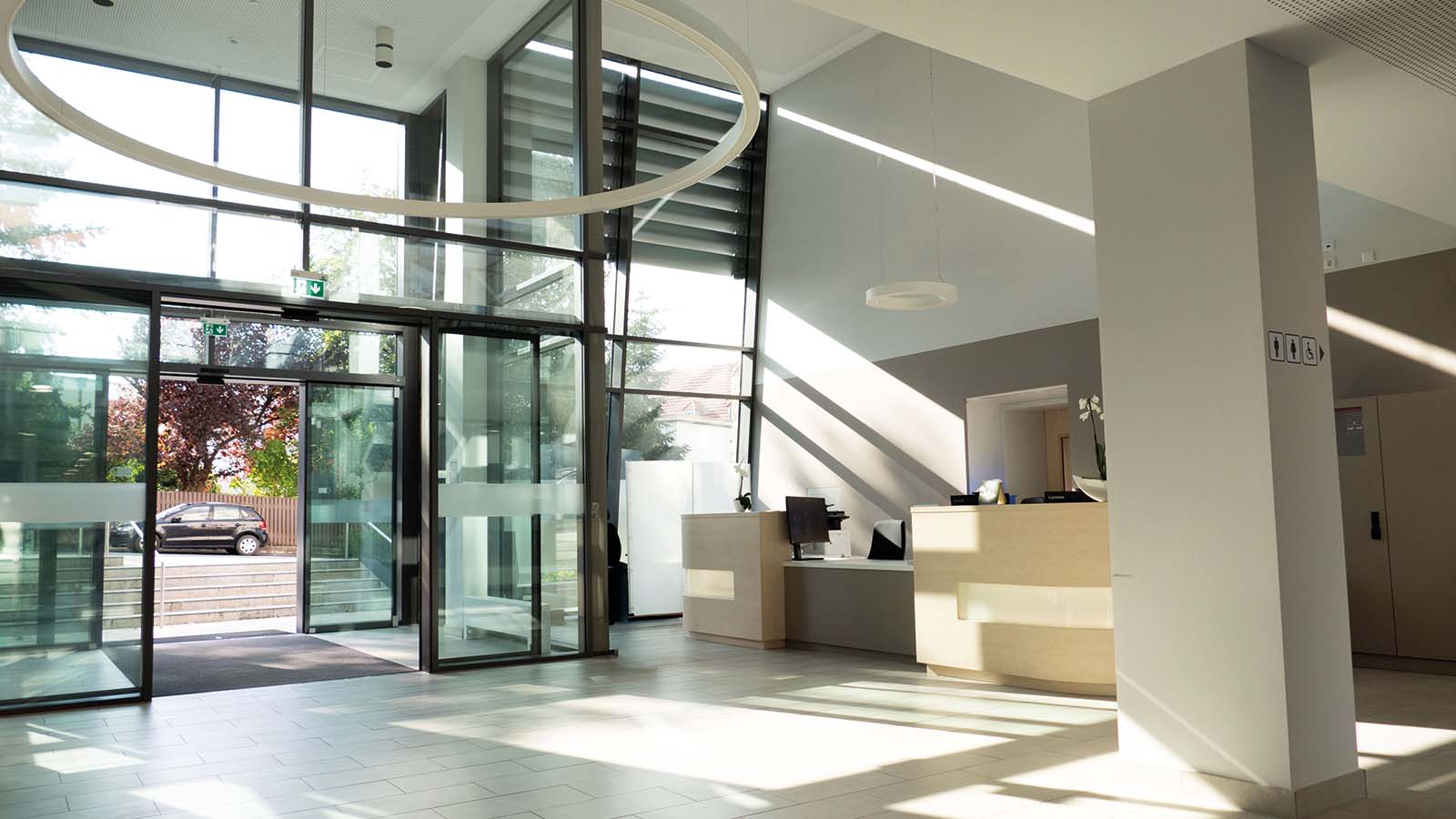 Modernes Bürofoyer mit Rezeption und Glastüren.