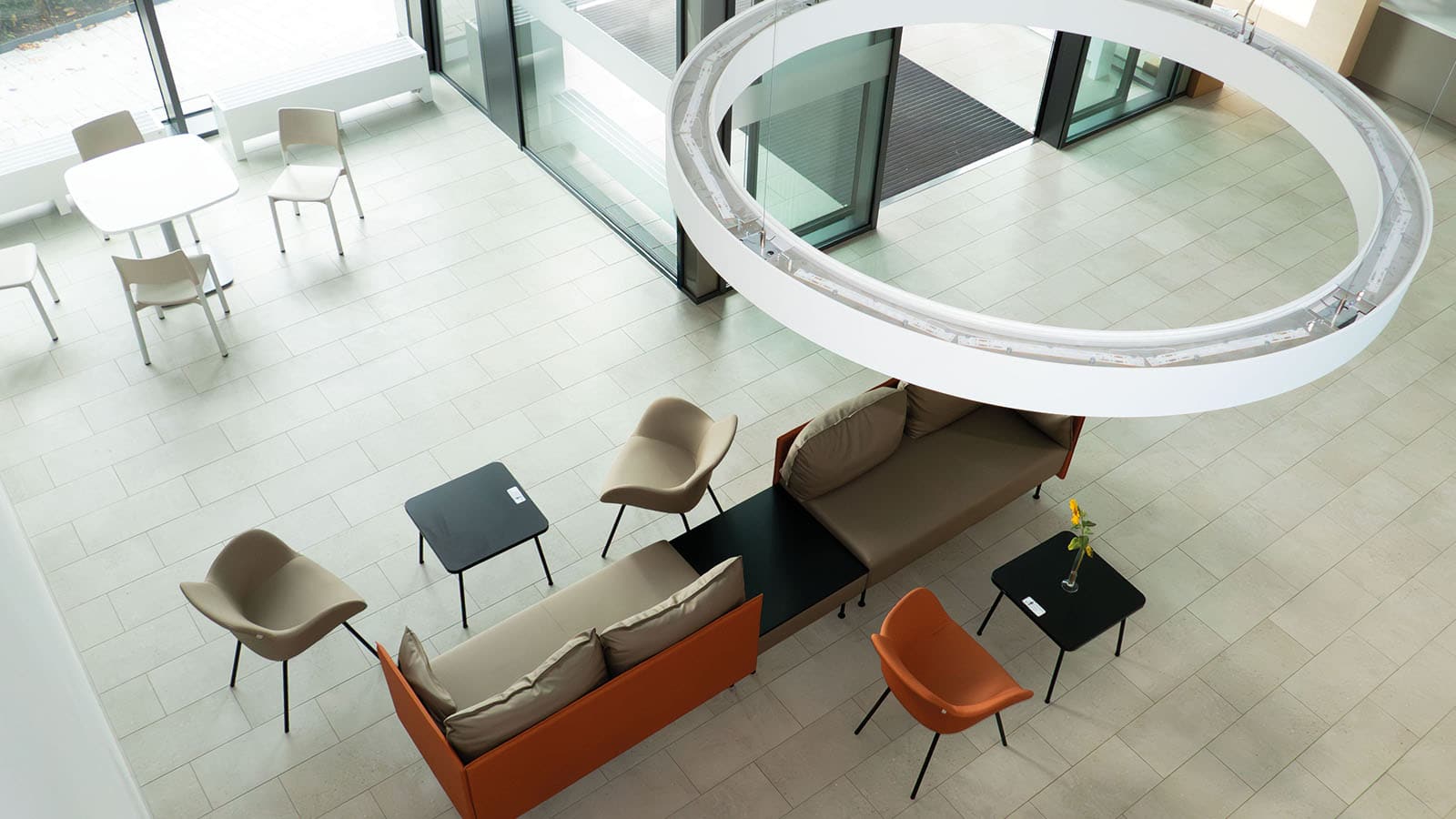 Moderner Lounge-Bereich mit Tischen und Stühlen von oben.