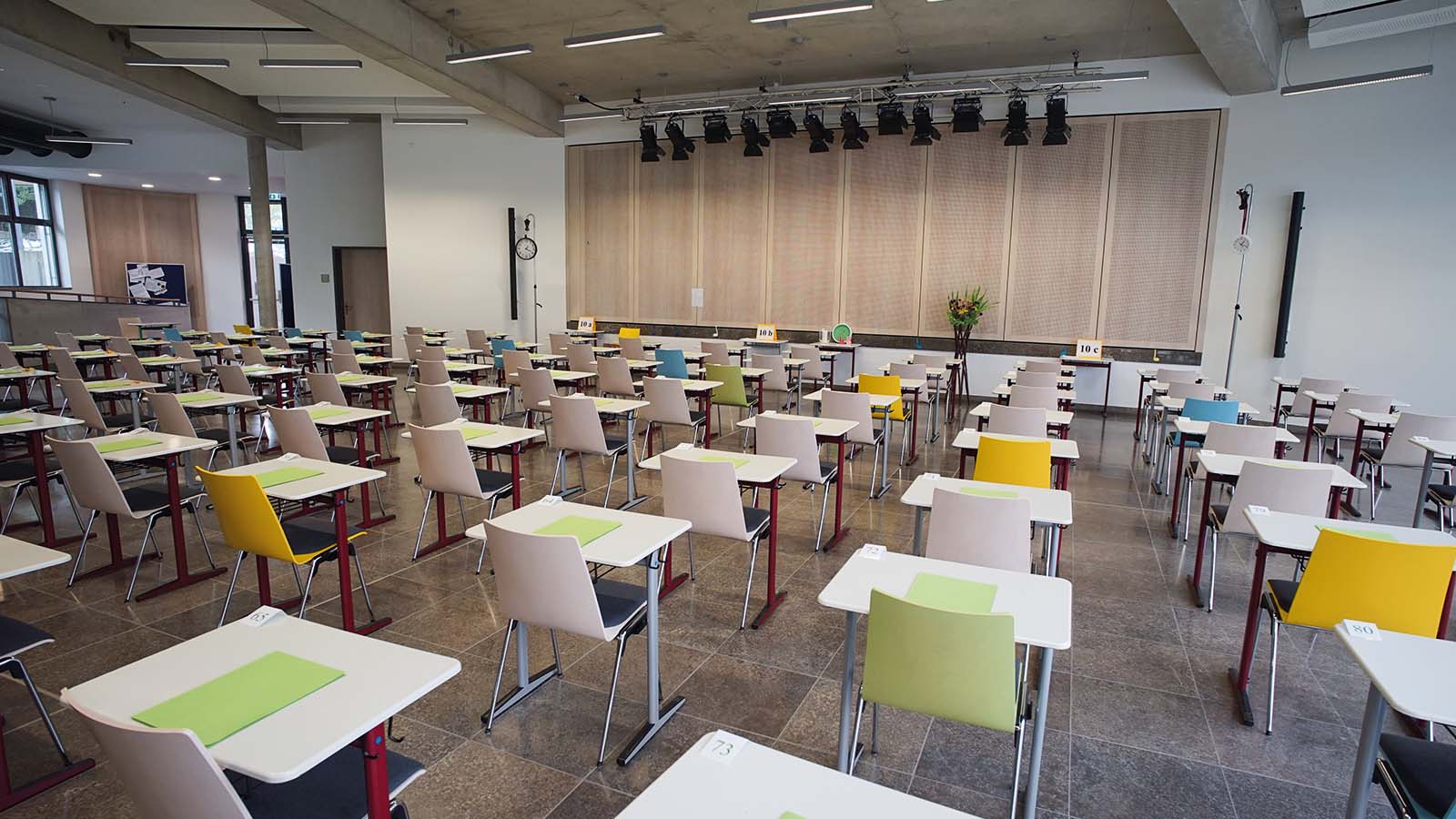 Leerer Hörsaal mit Stühlen und Tischen in Reihen.