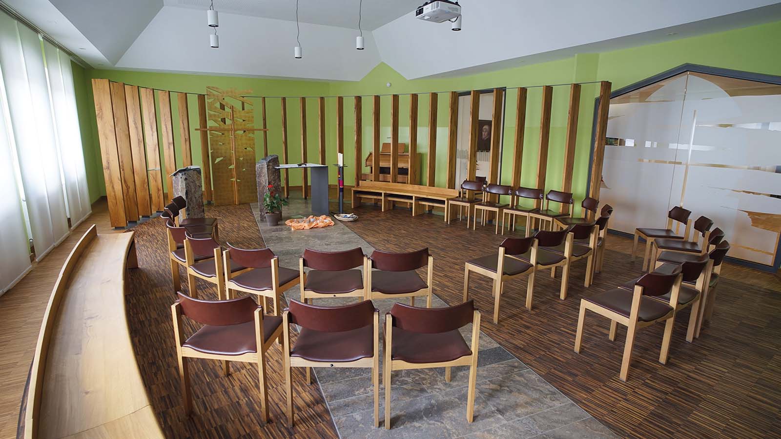 Moderner Versammlungsraum mit Holzstühlen und Podium