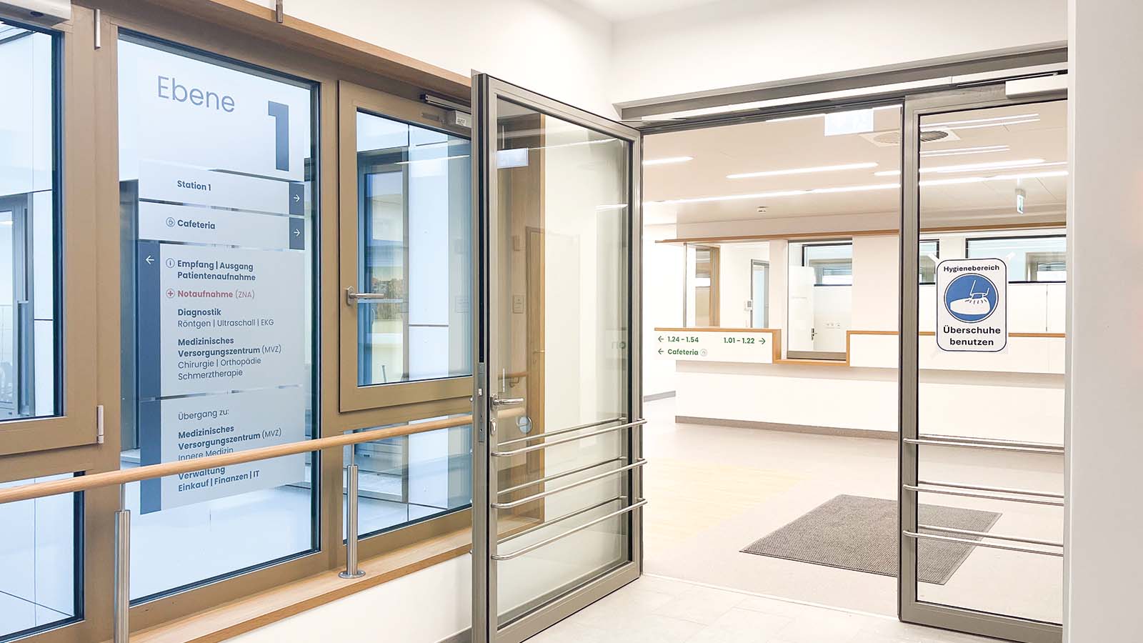 Krankenhauseingang mit Beschilderung und Hygieneschutzanweisung.