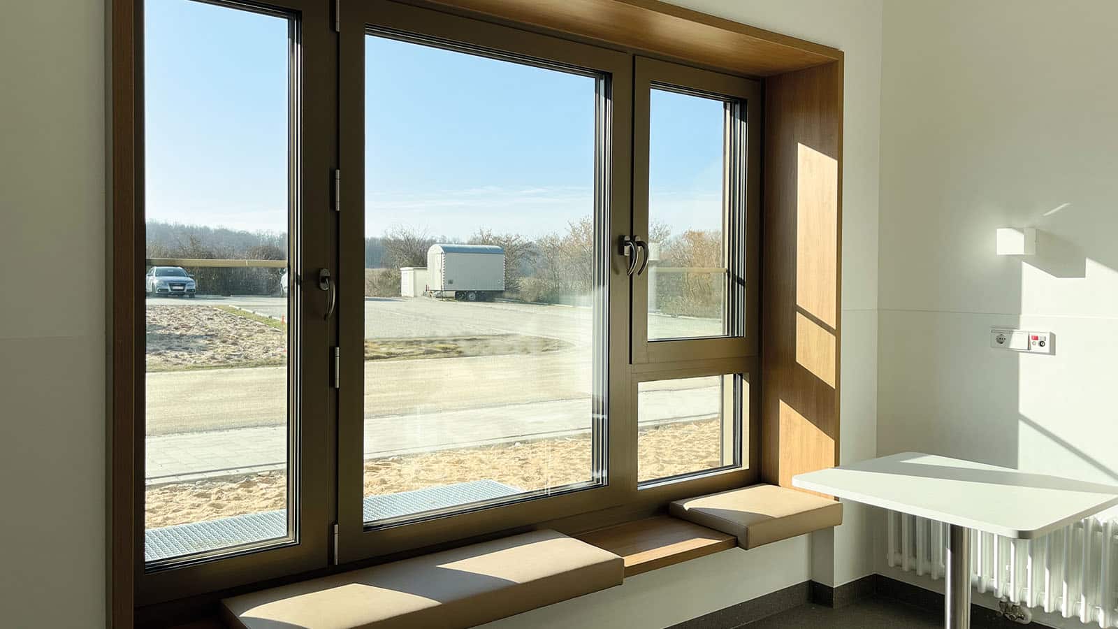 Großes Fenster mit Blick auf Parkplatz und Anhänger.