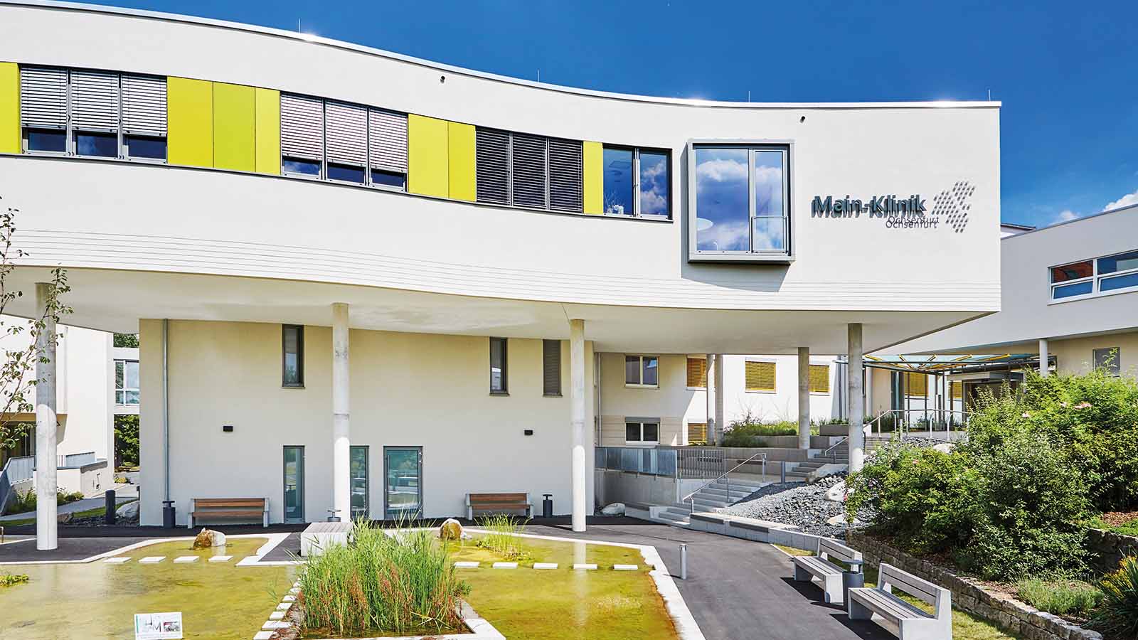 Außenansicht der modernen Klinik mit Garten