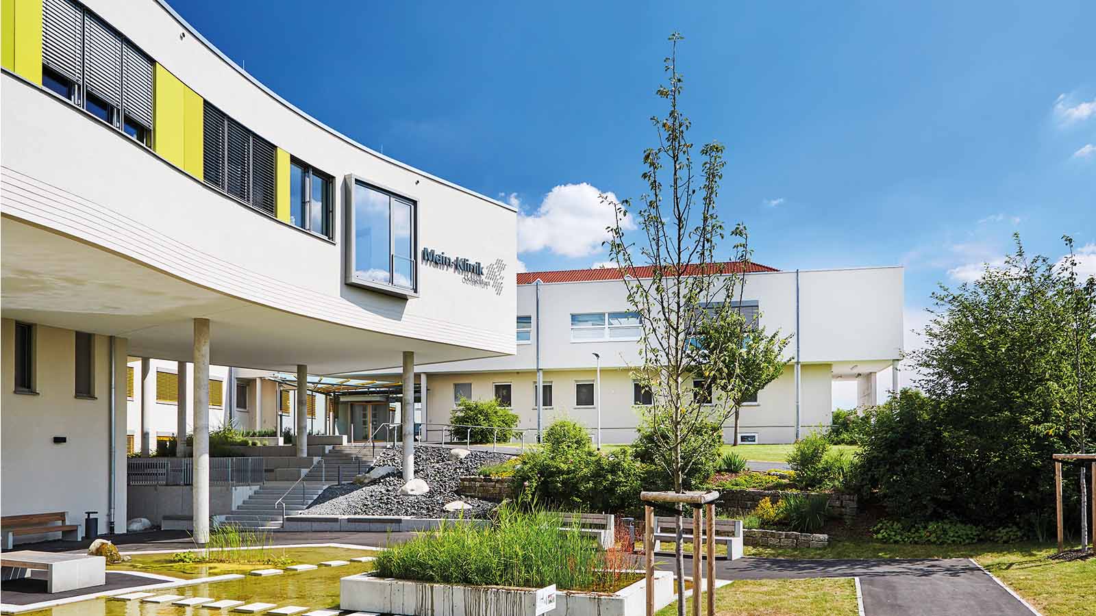 Moderne Klinikgebäude mit Garten und Treppen.