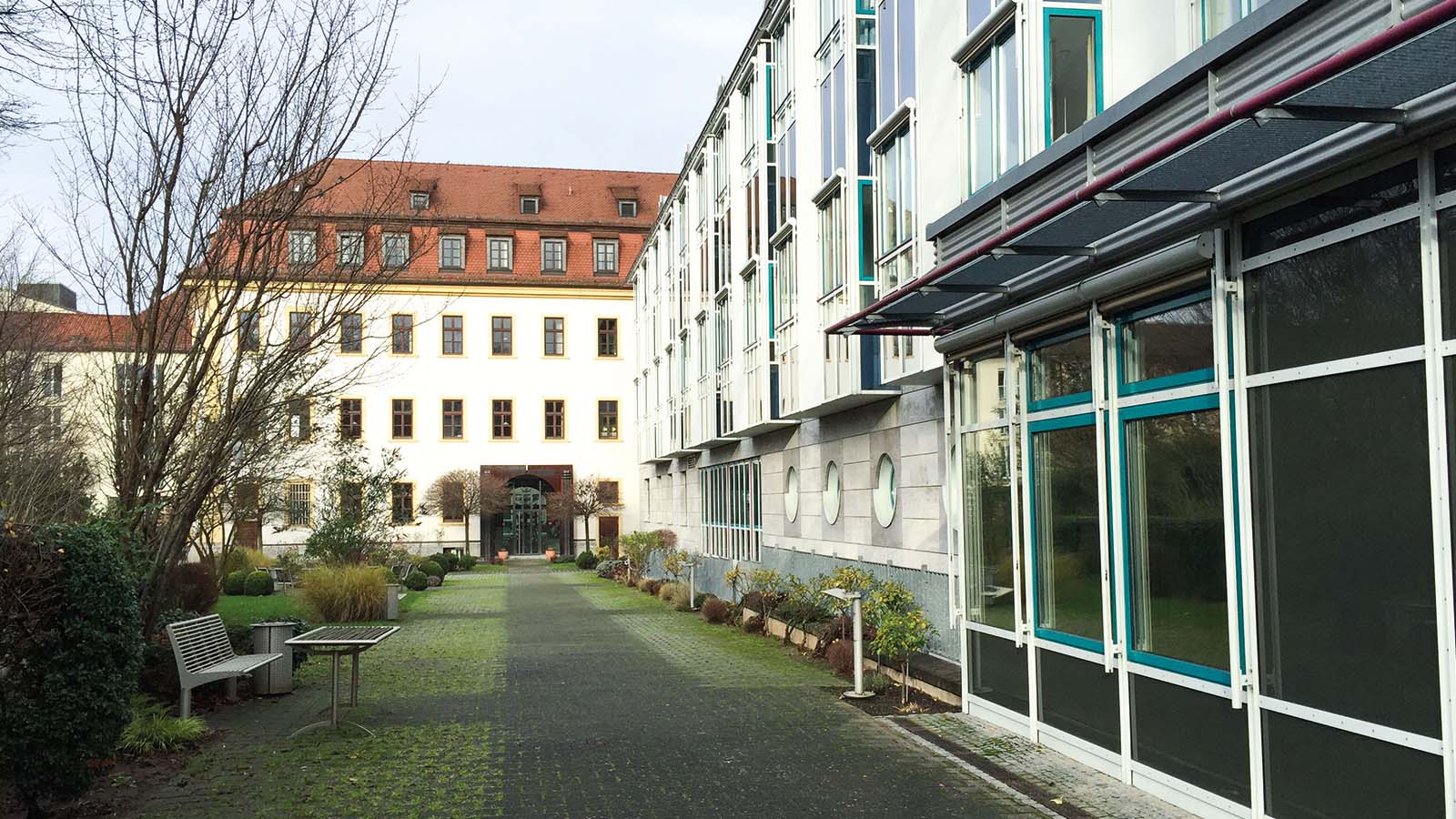 Moderne und historische Gebäudeansichten mit Gartenweg.