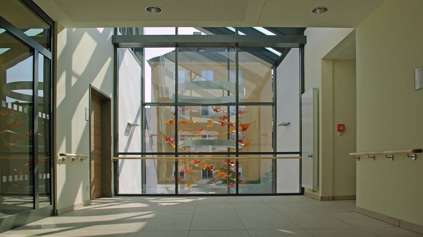 Moderner Krankenhausflur mit buntem Origami-Mobile
