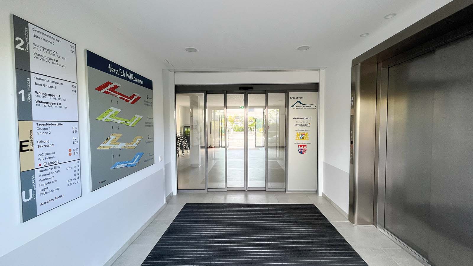 Eingangshalle mit Beschilderung und Aufzug