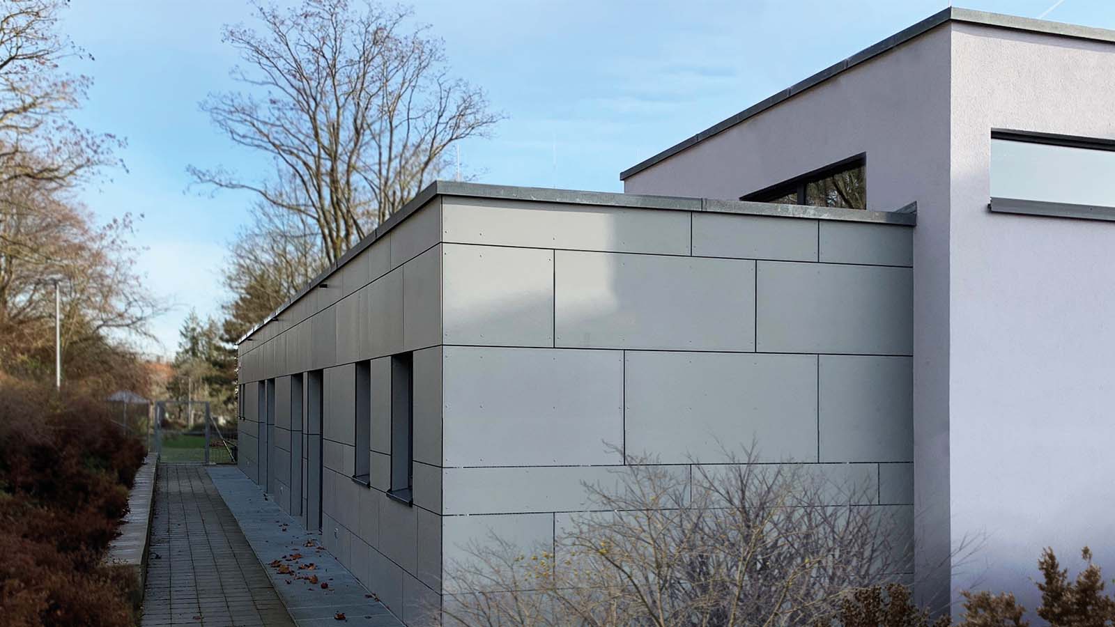 Moderne Gebäudeansicht mit Winterbäumen im Hintergrund