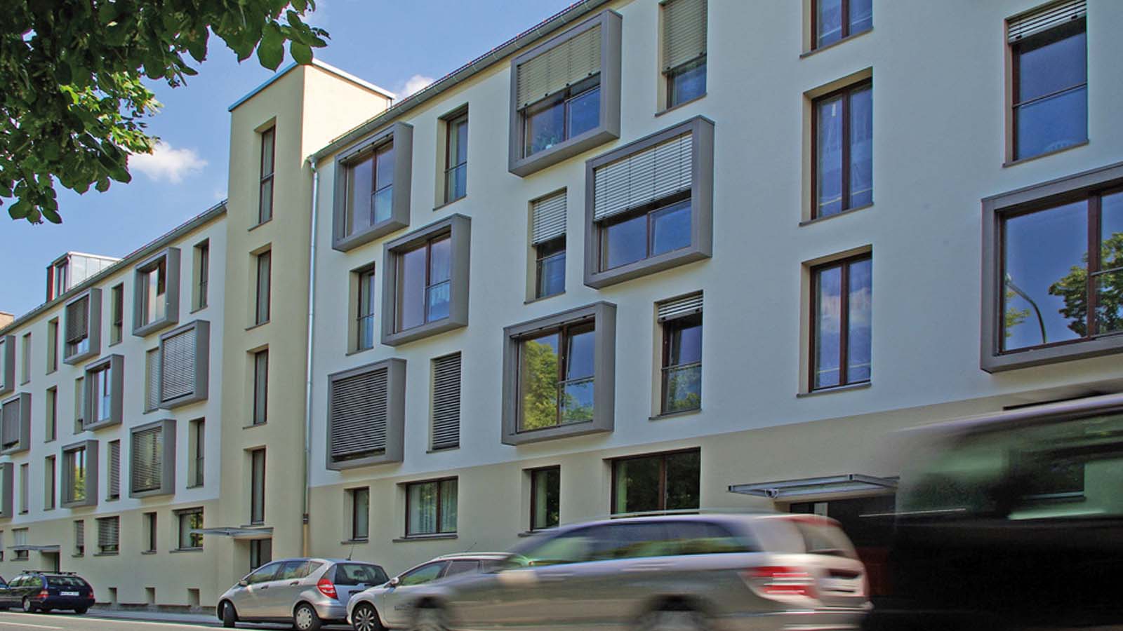 Modernes Wohngebäude mit geparkten Autos davor