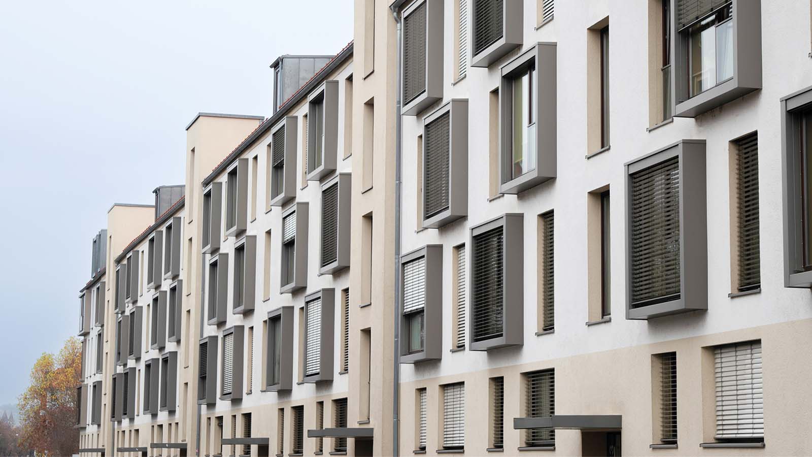 Mehrfamilienhäuser mit modernen Fenstern und Jalousien