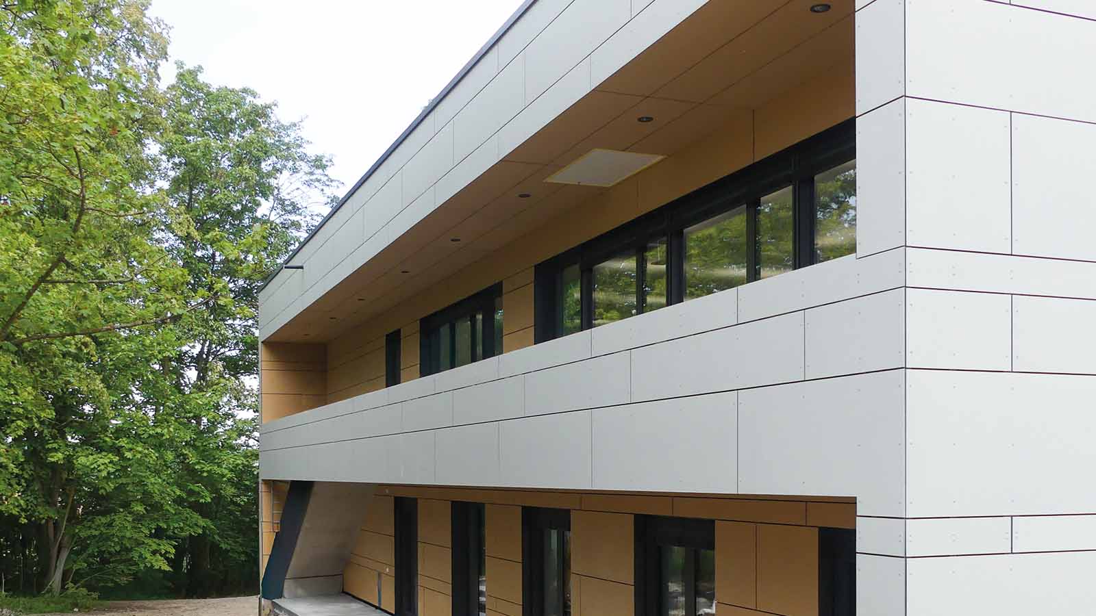 Modernes Gebäude mit großen Fenstern und Bäumen