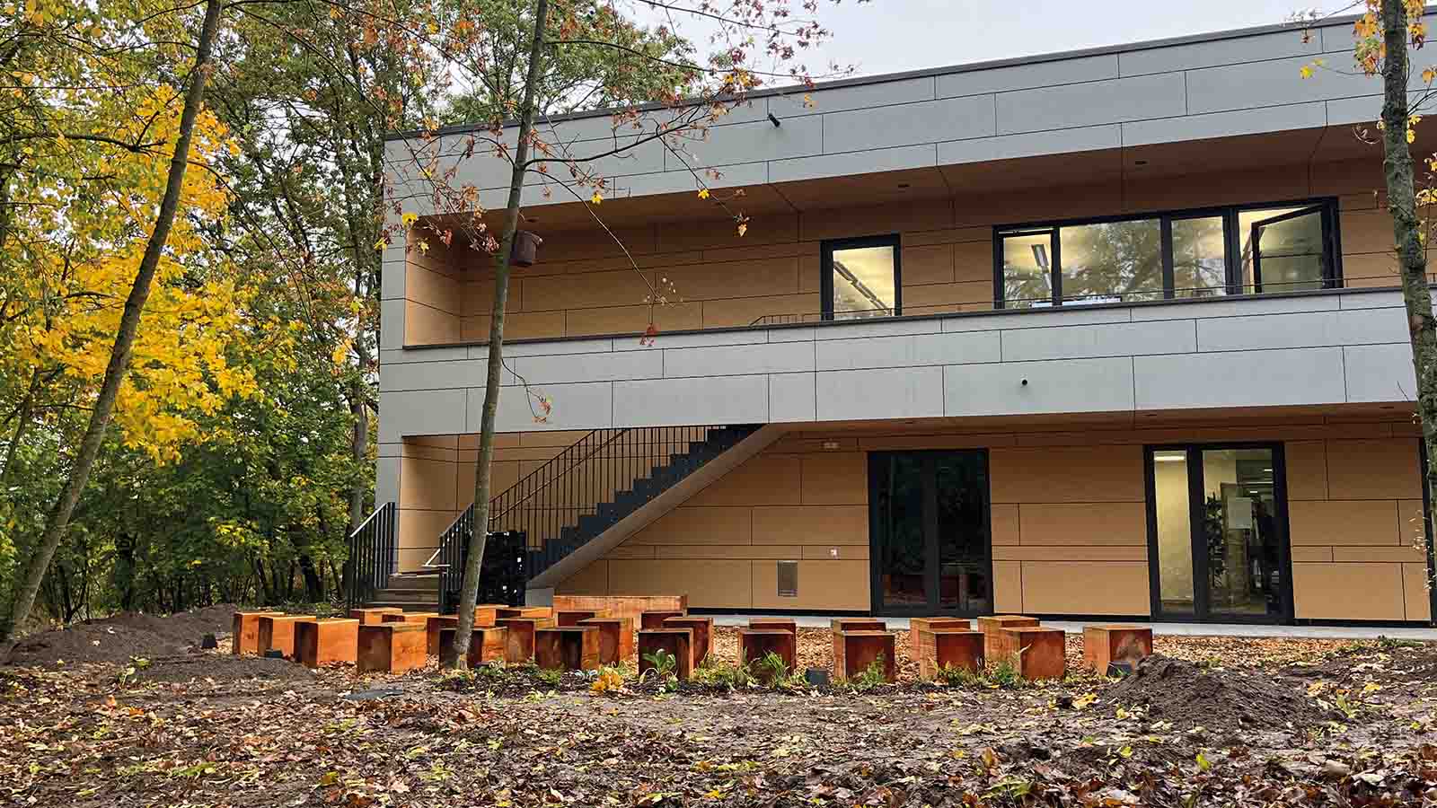 Modernes Gebäude mit Herbstbäumen und Außenbereich