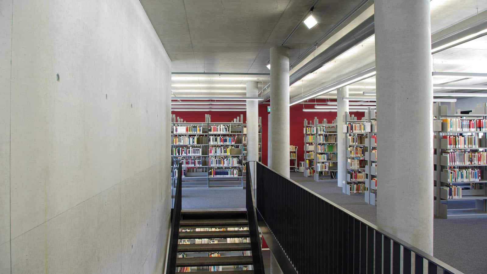 Moderne Bibliothek mit Regalen und Treppe
