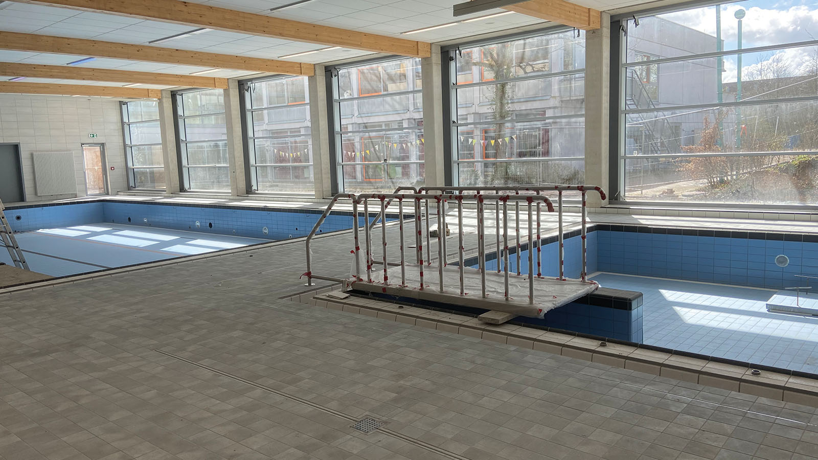 Leeres Schwimmbecken in hellem, modernen Raum.