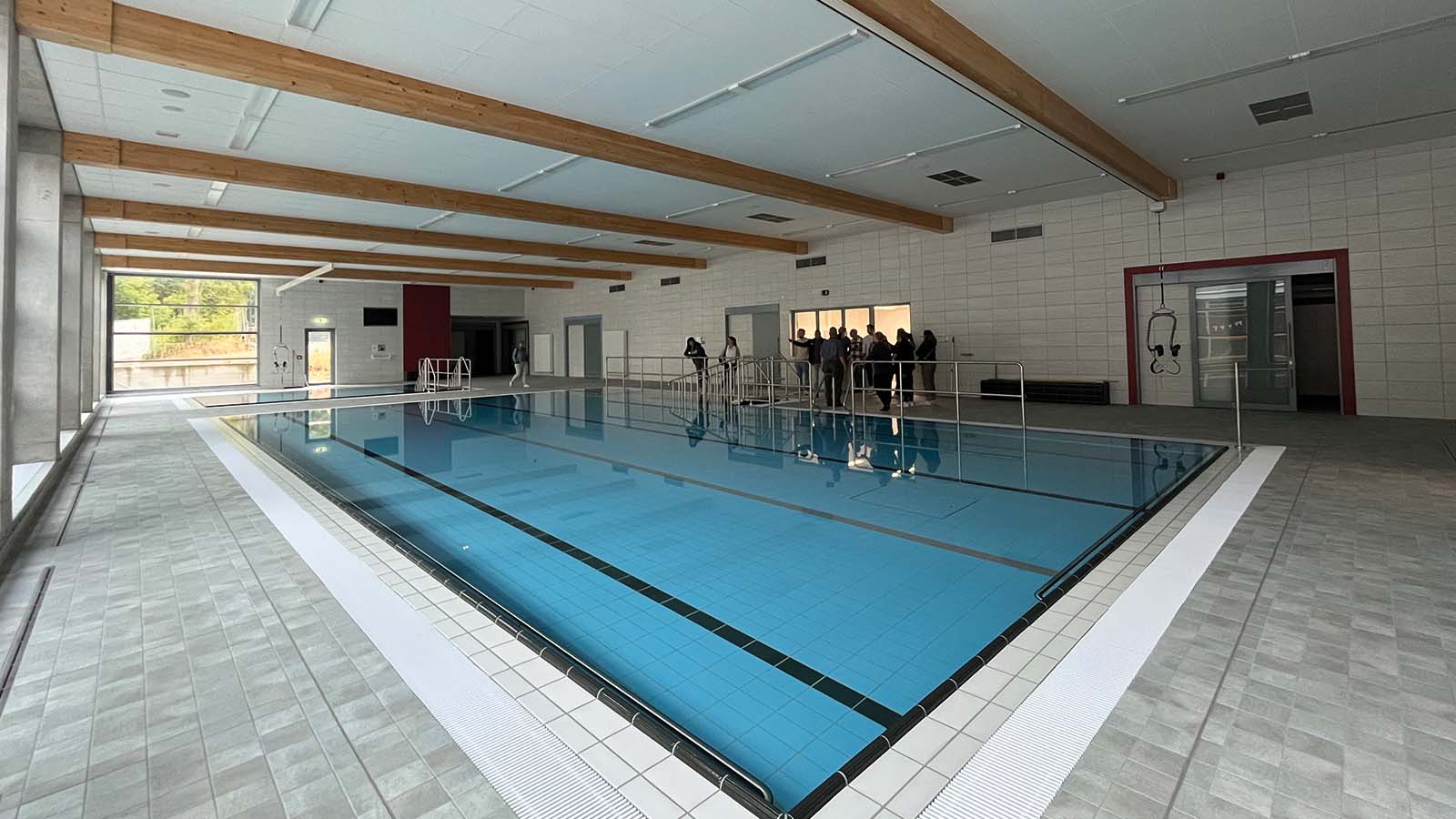 Hallenbad mit Menschen am Beckenrand