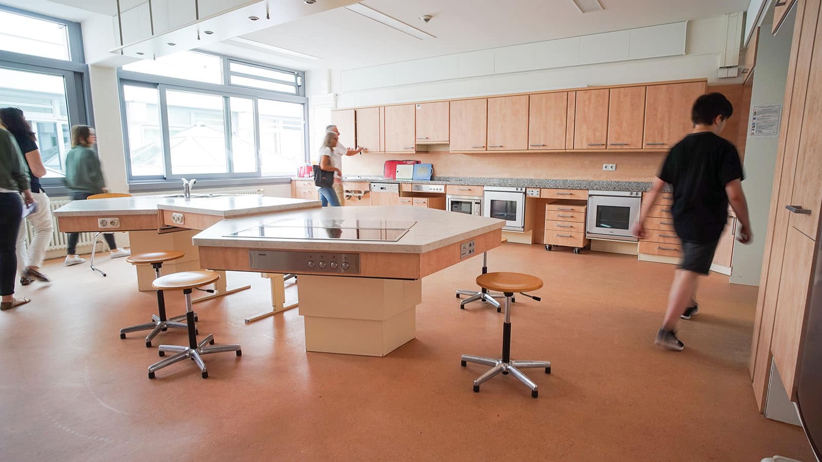 Moderne Schulküche mit Schülern beim Kochenlernen