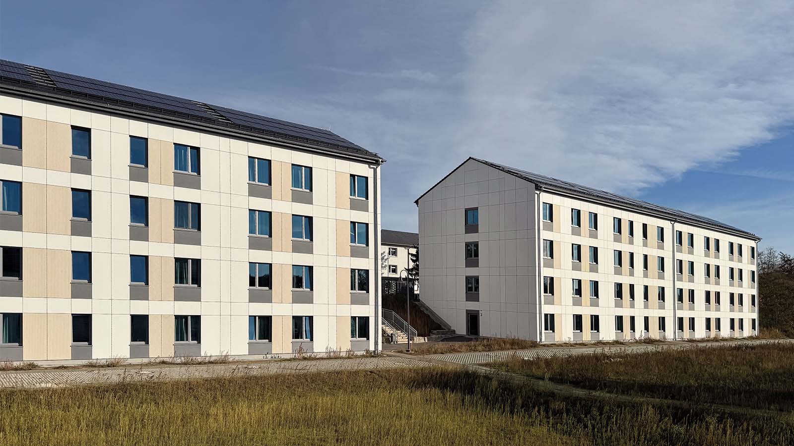 Zwei moderne Wohngebäude mit Solaranlagen.