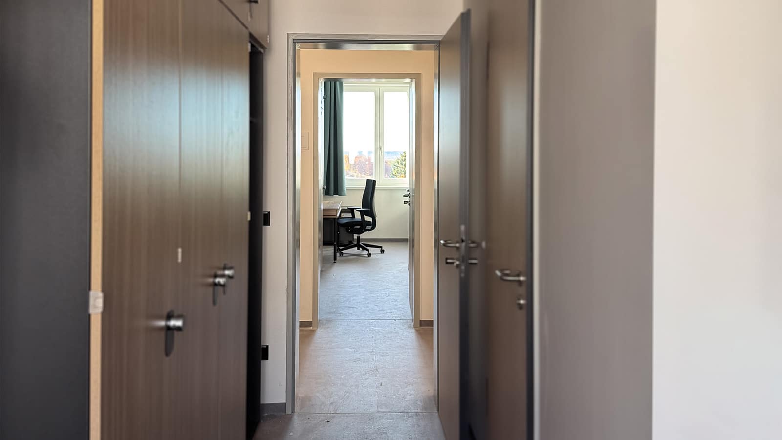 Büro mit Schreibtisch und Stuhl durch Tür sichtbar.