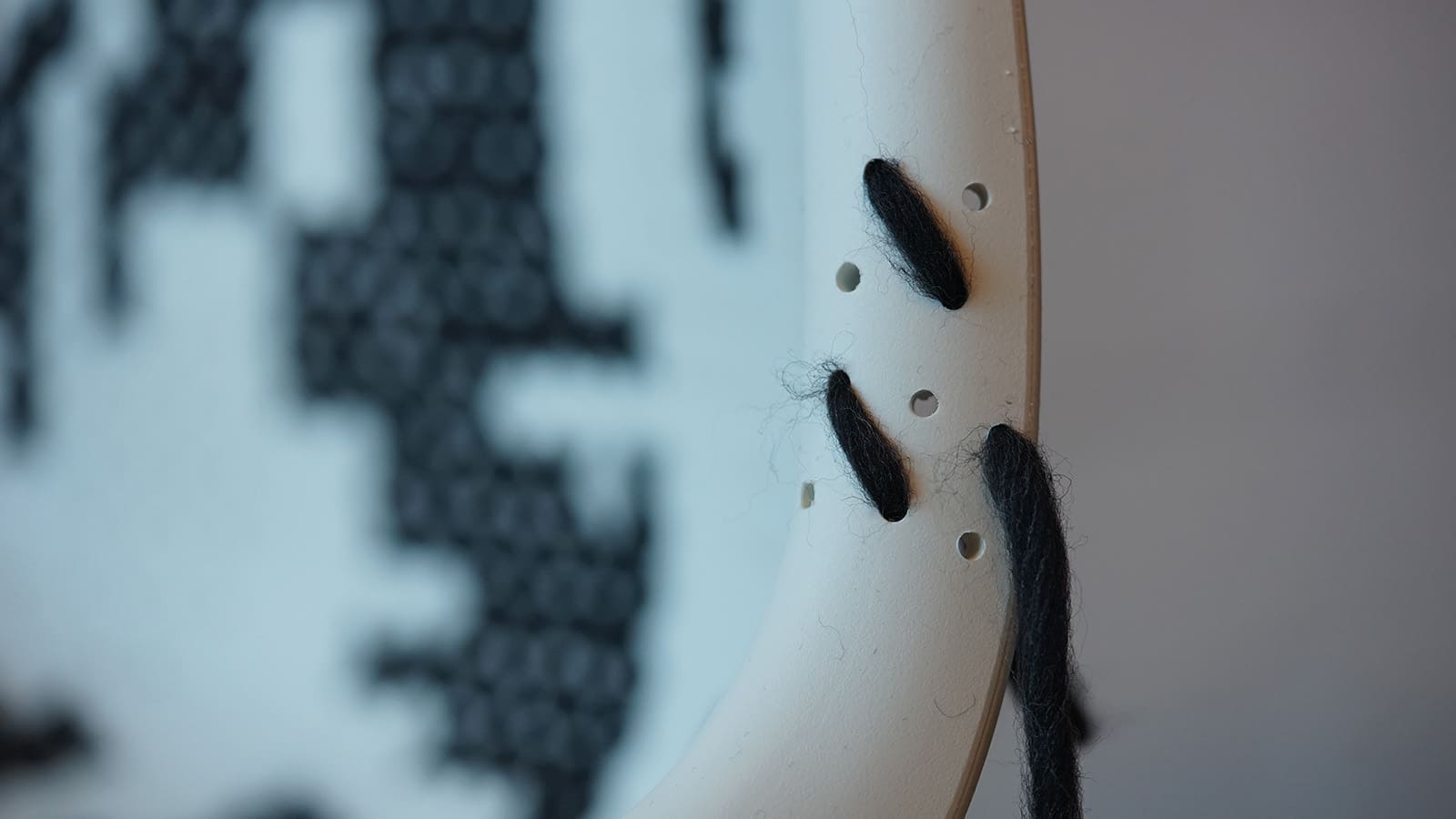 Nahaufnahme eines gestickten Stoffstücks mit Rahmen.