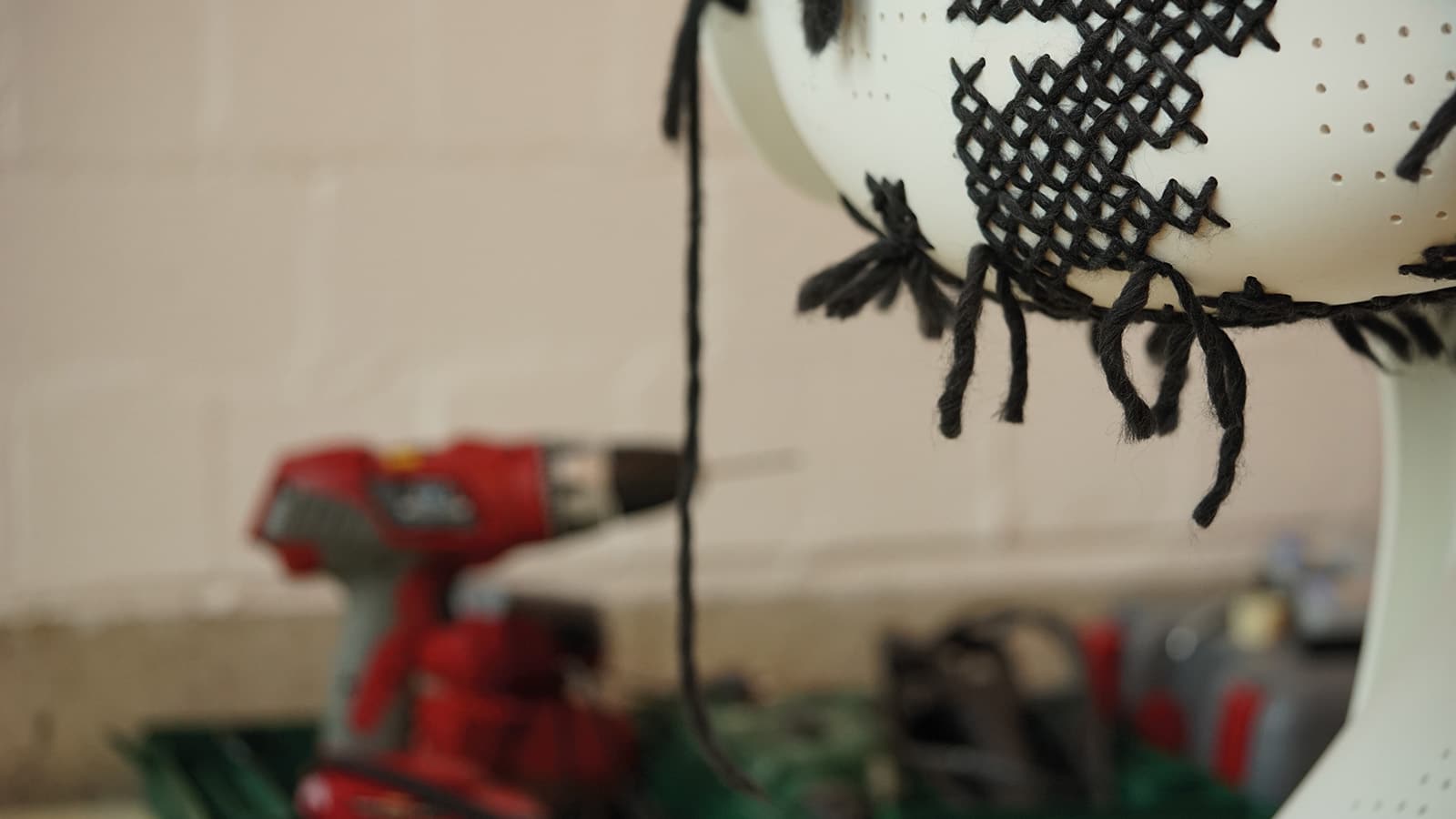 Strickkunst mit Bohrmaschine im Hintergrund