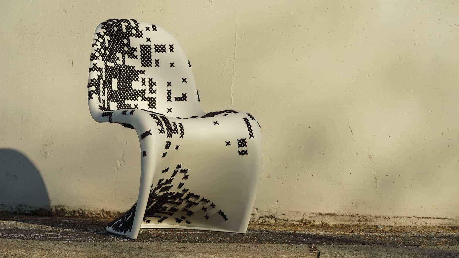 Designer-Stuhl mit pixelartigem Muster vor Wand